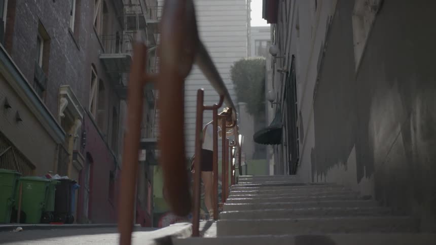 A woman is leaning on the handrail in the alley