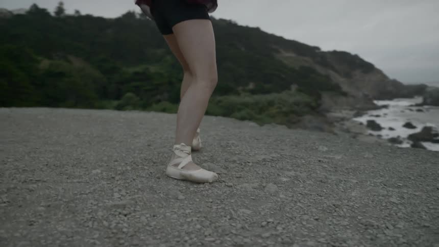A ballerina dances on the beach