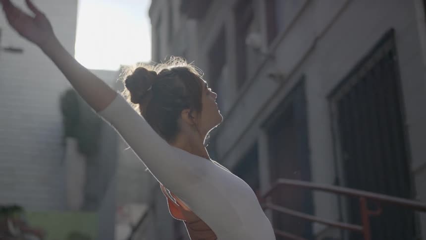 Dancer dances outdoors in street near building