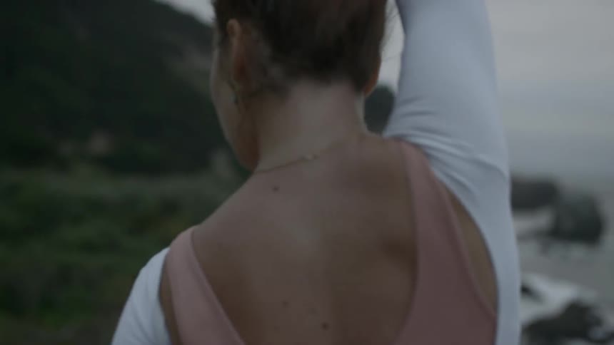 Ballerina moves rhythmically following a set sequence of steps on the hill by the seaside