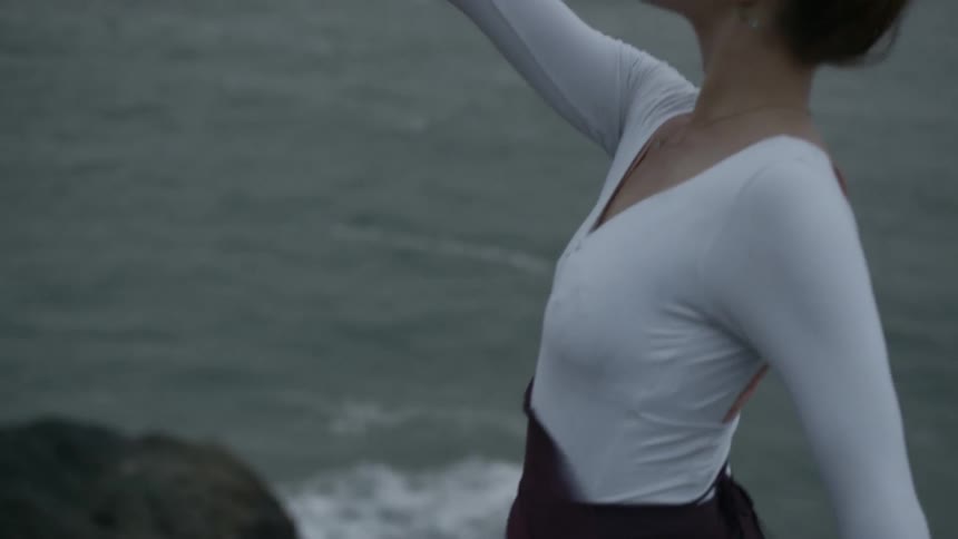 A woman dancing under the wind at the beach coastal