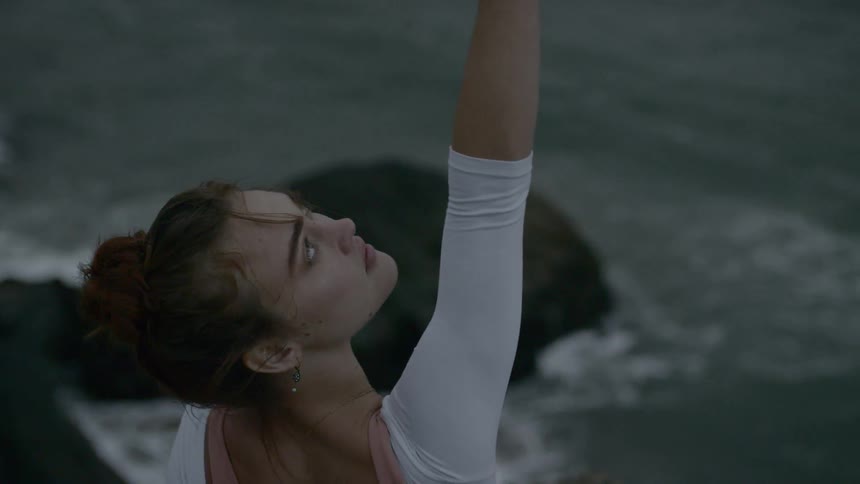 A ballerina dances above the sea
