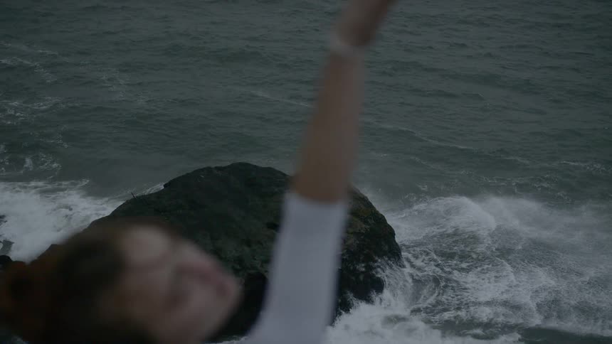 Dancer stretches toward the sky on the beach