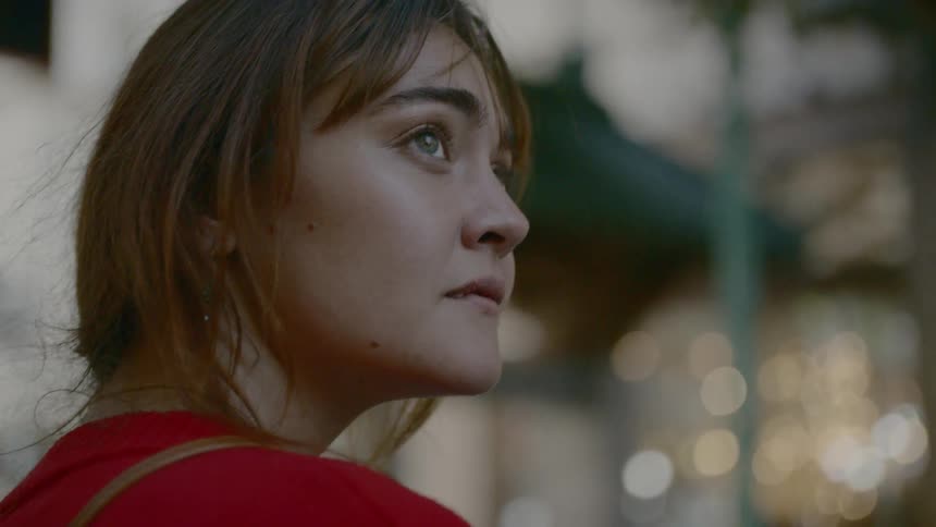 A woman is looking around outside