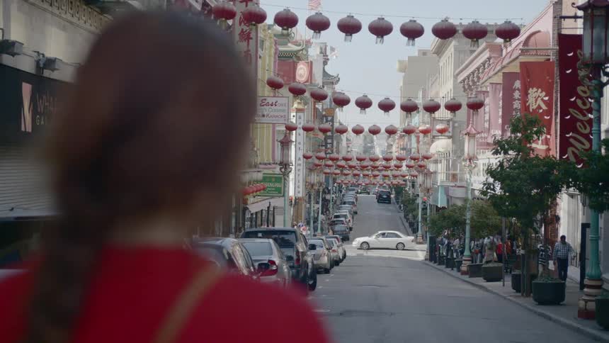 A young woman stands in a street