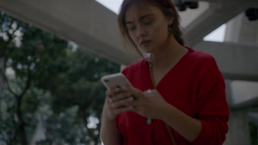 A woman walking typing on her smart phone