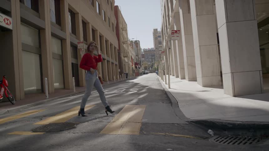 Woman crosses empty street in crosswalk