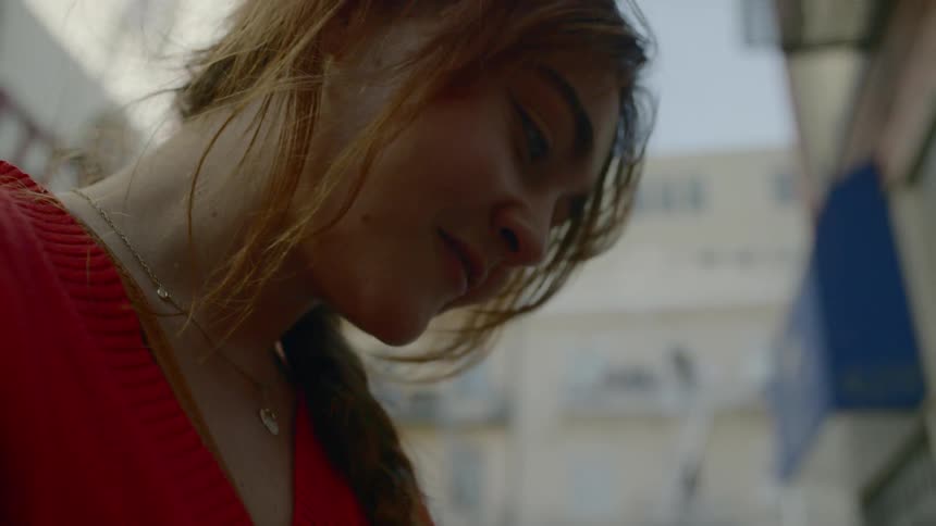 A woman looking at a phone in a city