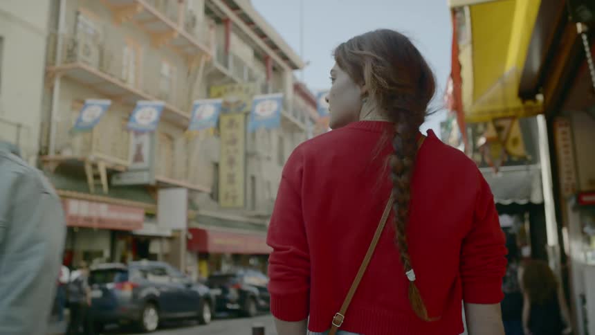 A woman walking on a sidewalk next to shops
