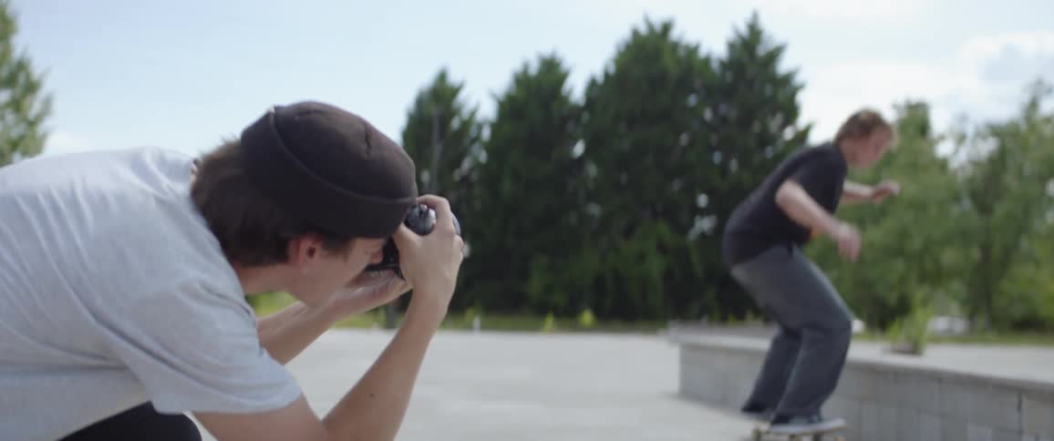 A photographer takes pictures of a skateboarding skating