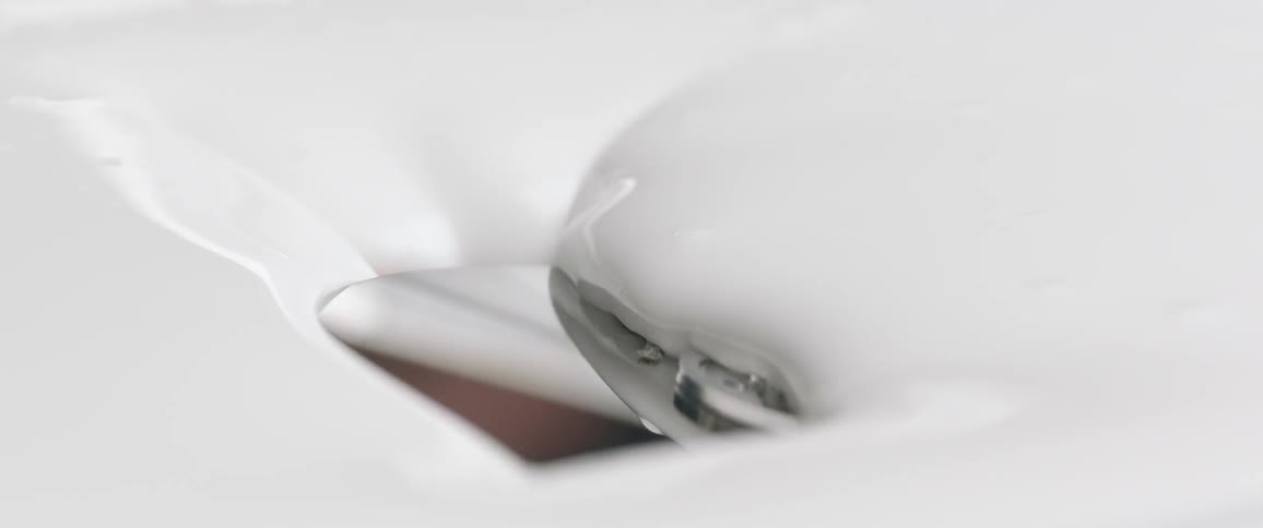 A thick white fluid coats a metal product