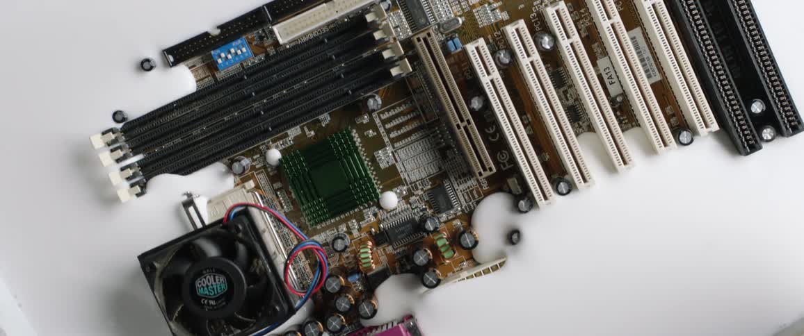 A computer motherboard slowly sinks into a think white liquid that looks like glue