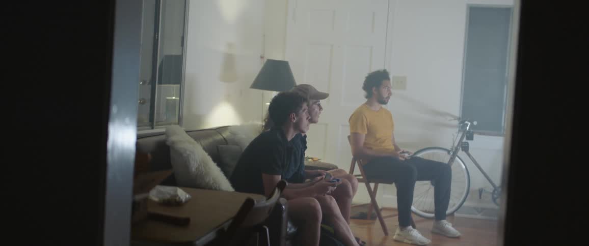 A group of friends sit inside and play video games together