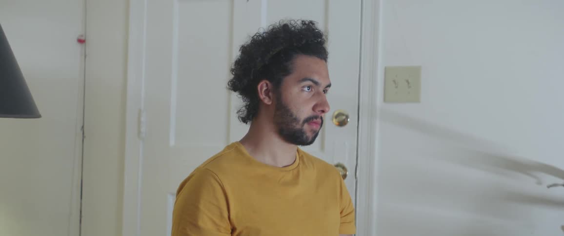 Man sits near a door staring straight ahead