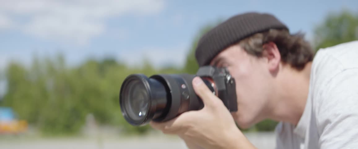A man holds a professional camera up to his face to take a picture