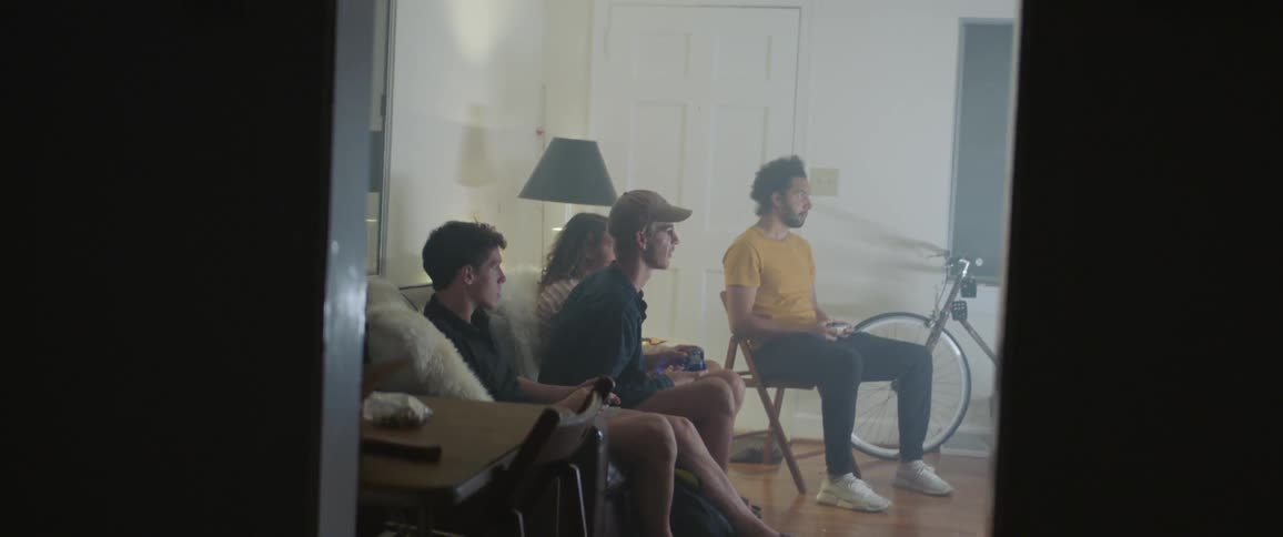Friends sit in living room playing video games