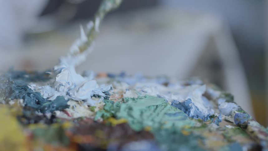 A woman dips a tool in paint