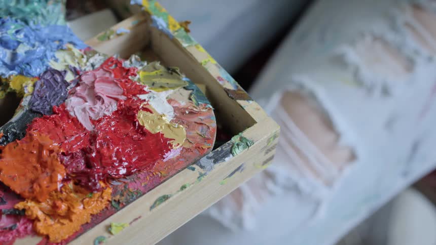 A woman touches a box filled with paint swatches