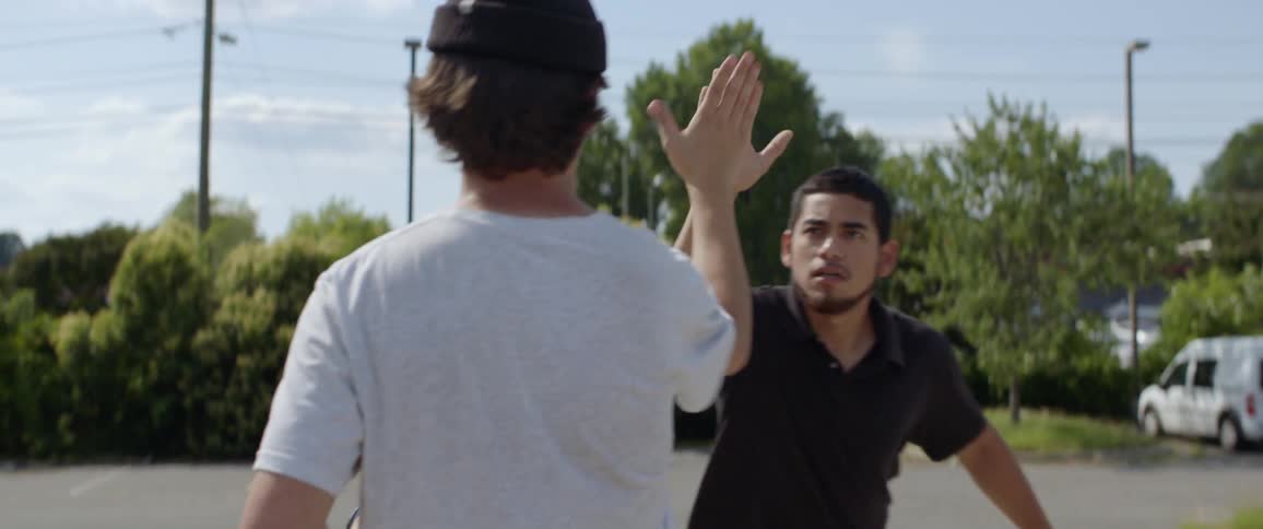A photographer high fives a skateboarder as he walks by