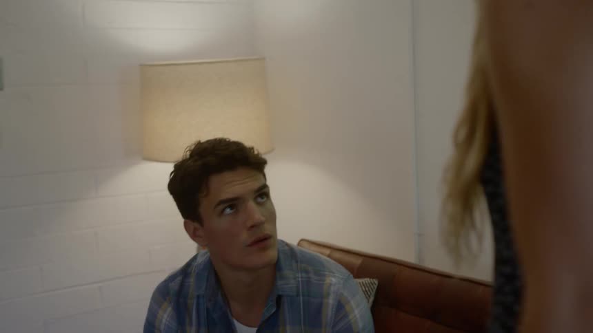 A woman arguing with a man who is sitting on a couch
