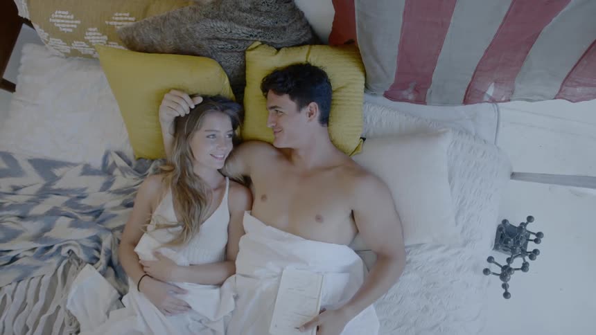 A man and woman lay together in bed