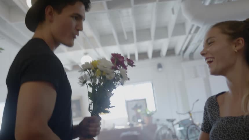 A man surprises his girlfriend with flowers