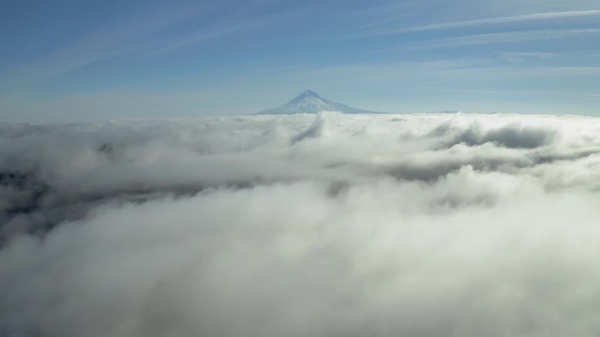 Thick clouds in front of a mountain top
