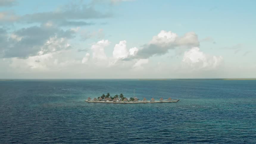 An island in the middle of tropical turquoise ocean water