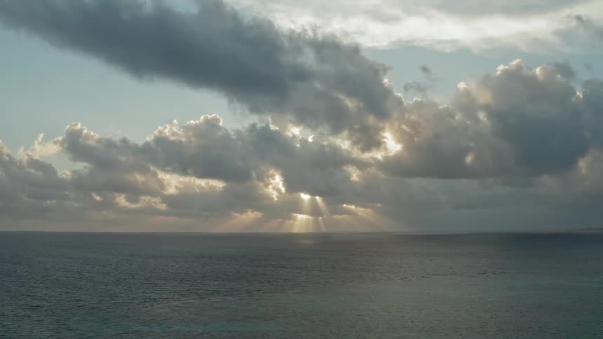 Sun goes down behind the clouds above the sea