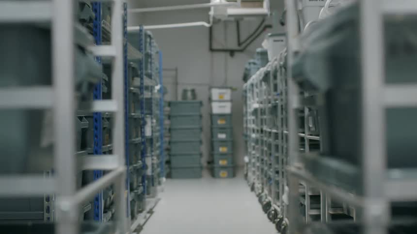 Plastic tubs stored on rows of metals shelving units