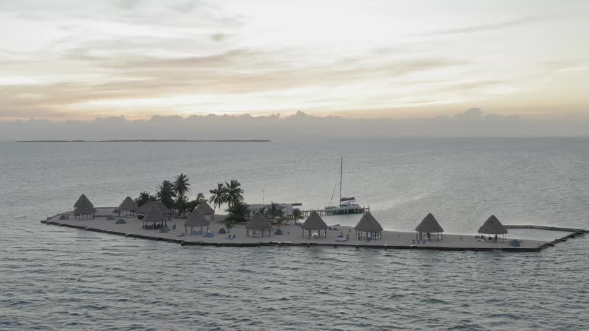 A small island with palm trees with the sky in the background