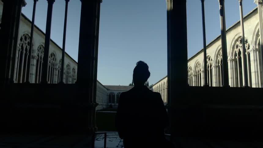 A silhouette of a man walking through the gate