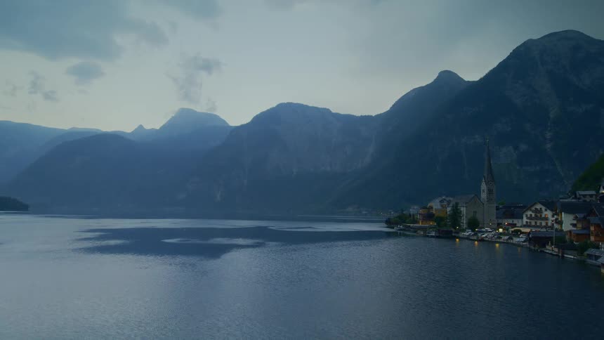 A church and village on lake hallstatt surrounded by mountains