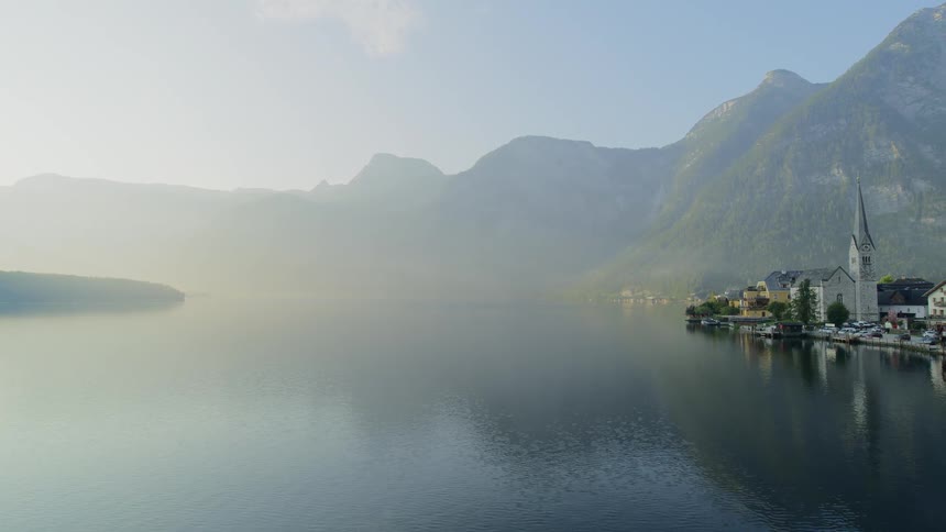 A small coastal neighborhood covered in fog by the lake and mountains
