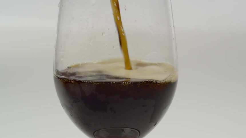 A beverage is being poured in to a glass
