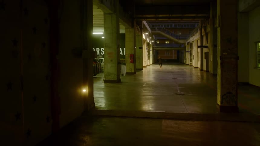 A woman walks into a dimly lit parking garage