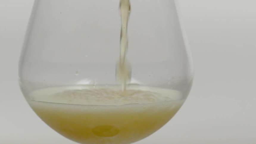 Beer being poured into a glass and creating foam