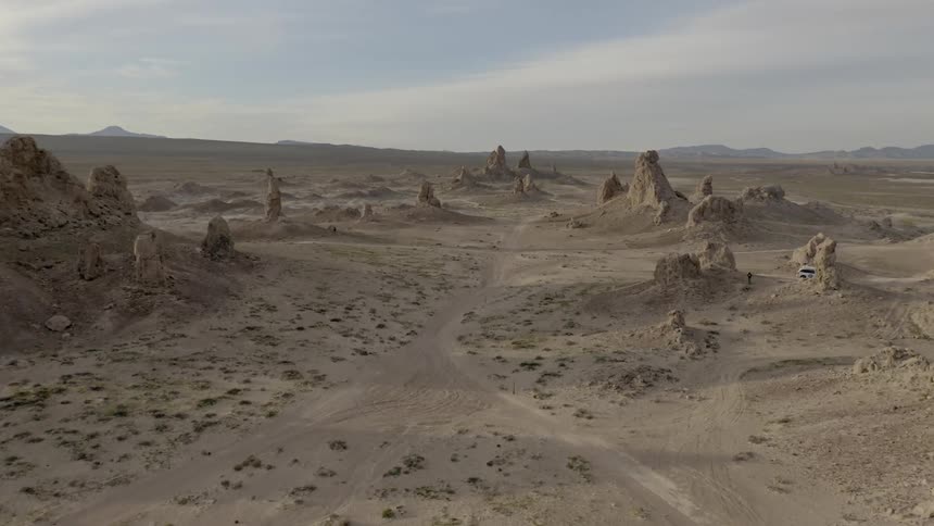 Tracks and trails in the desert sand around rock formations