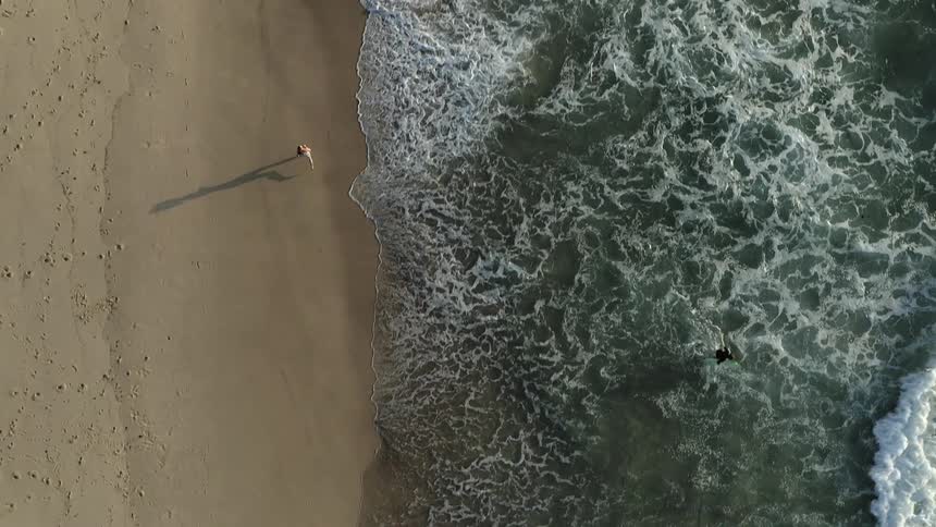 A person running along the beach during the day