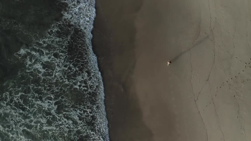 A person runs across a beach