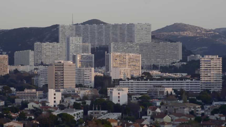 Tall office buildings loom above and behind a neighborhood