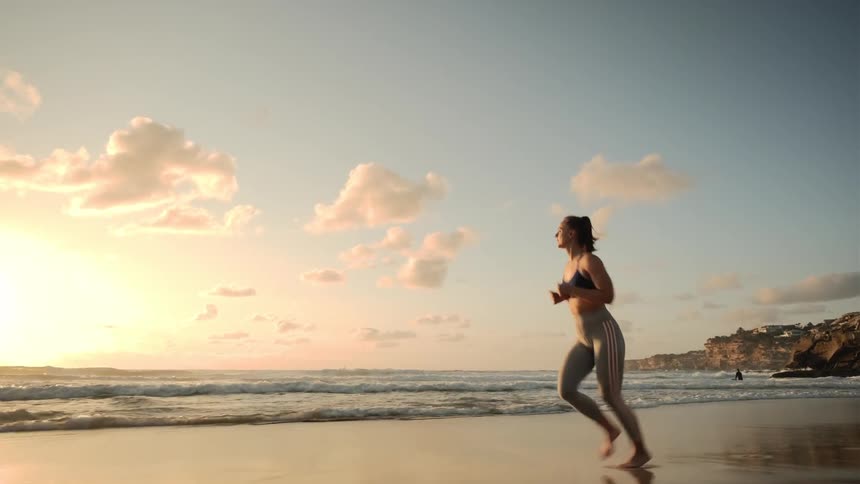 A young woman runs along the beach