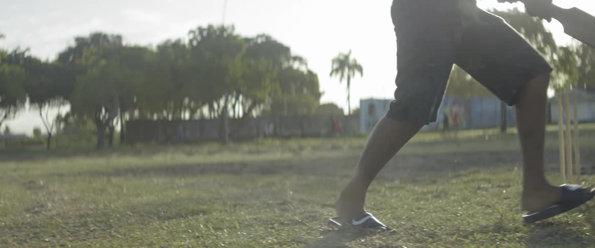 A man hits a ball with a cricket bat and runs