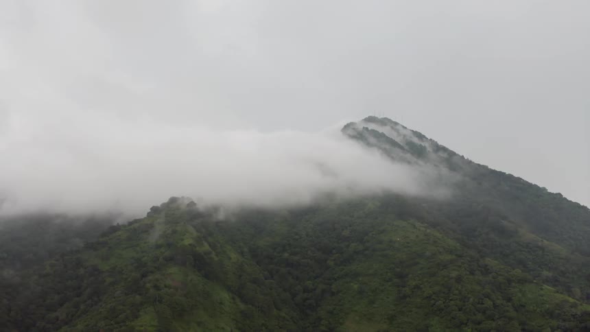 Clouds partially cover a mountain peak