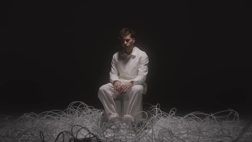 A man sits in the middle of cords