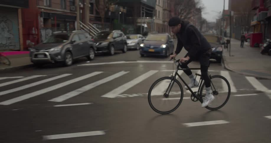 A man rides his bike down a city street