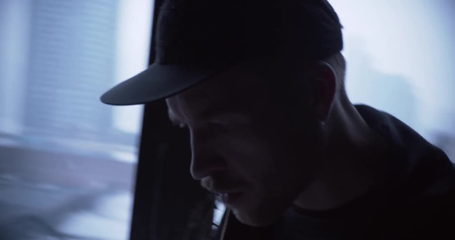 A young man inside a building turns his head and looks up