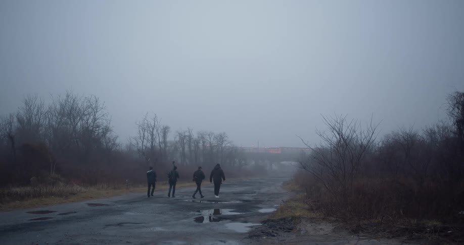 People walk down a misty road