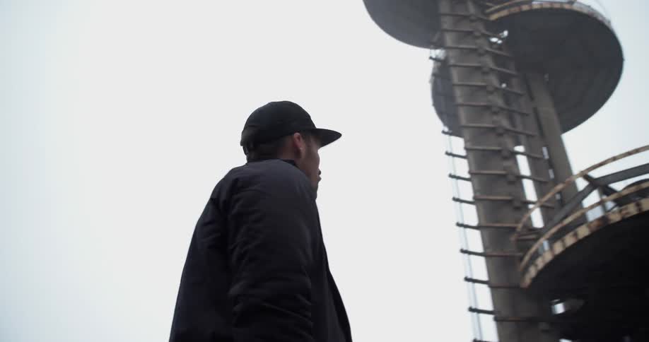 A man stares at a large piece of architecture and walks away