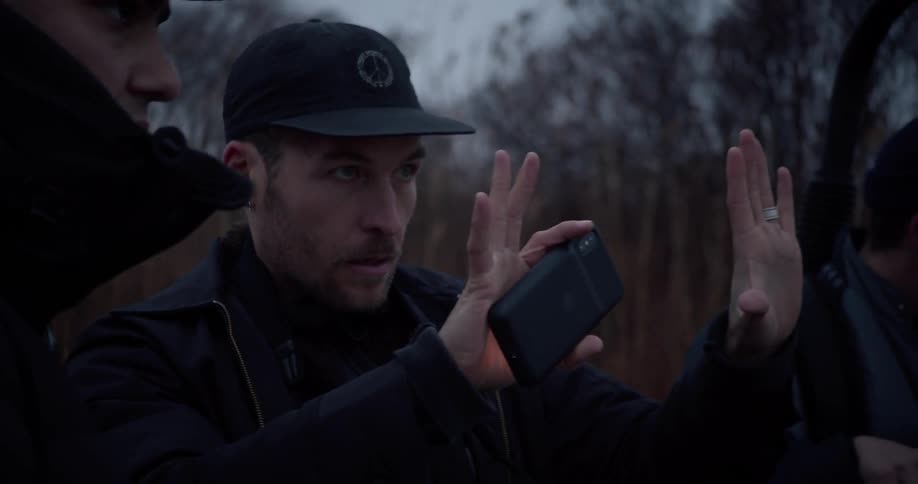 A man holds his hands in the air and looks through them